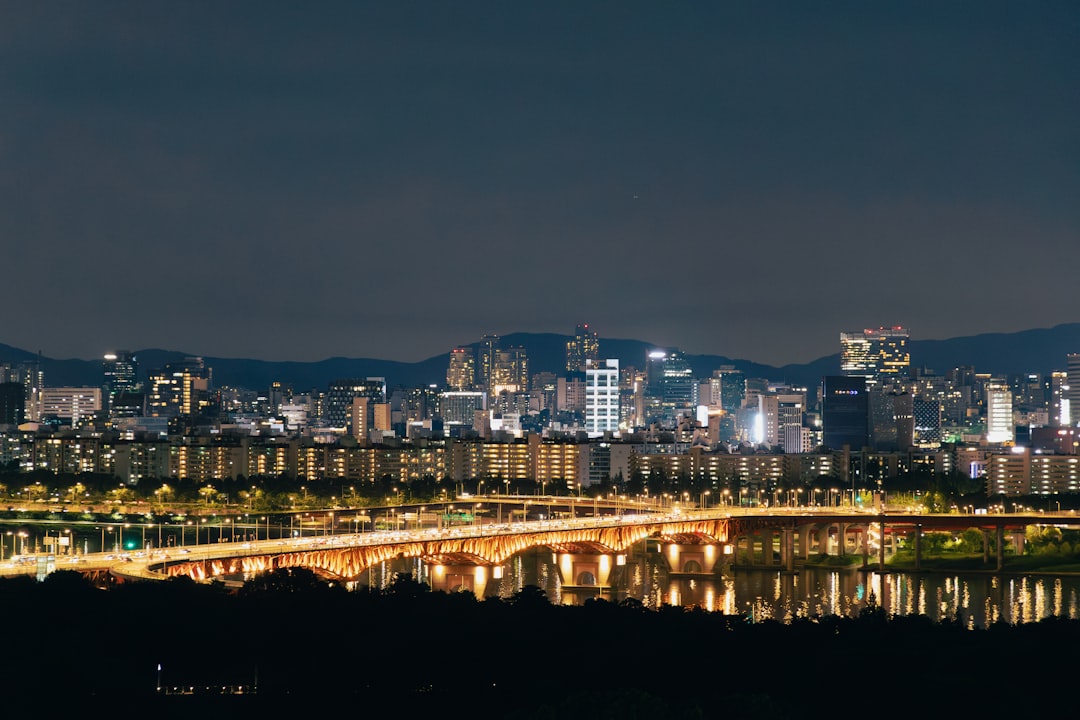 Vibrant cityscape at night with a lit bridge over water